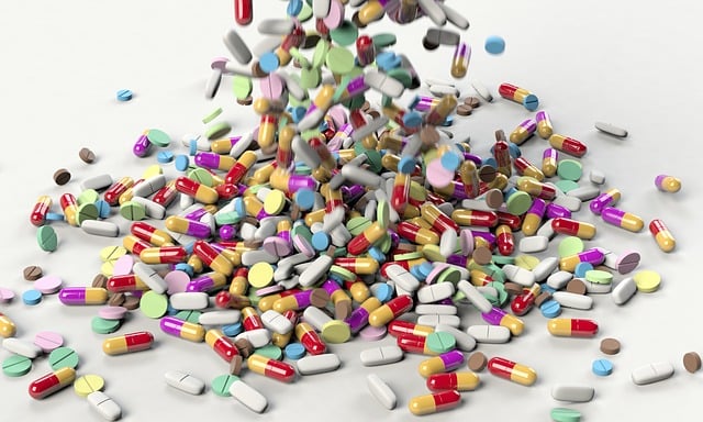 Lots of colorful pills being dropped into a pile